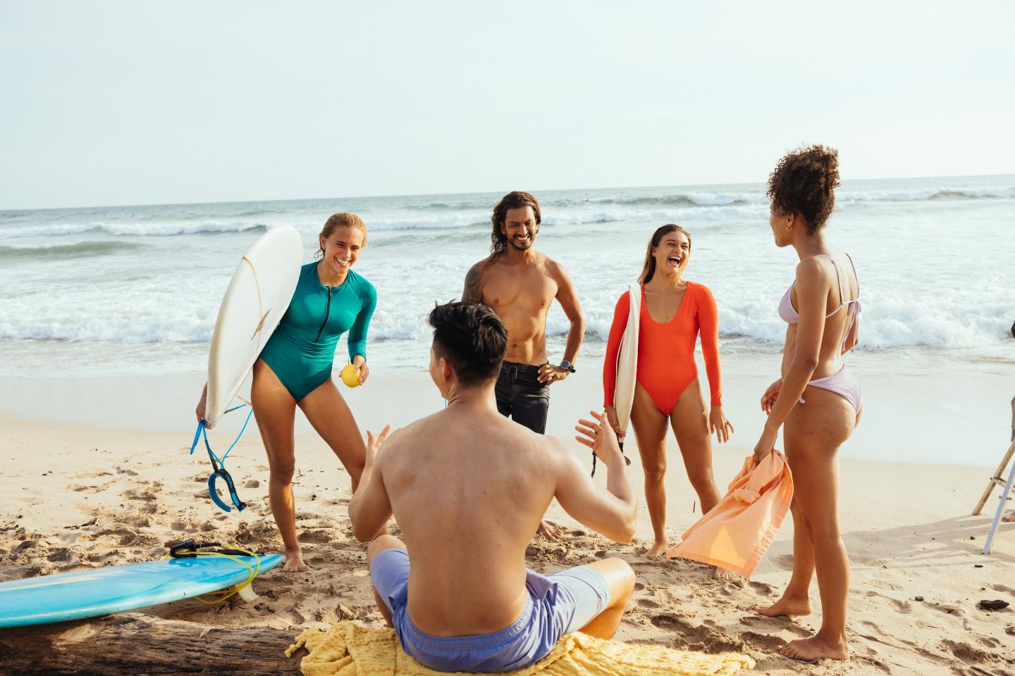 friends laughing with surfboards on beach guiones